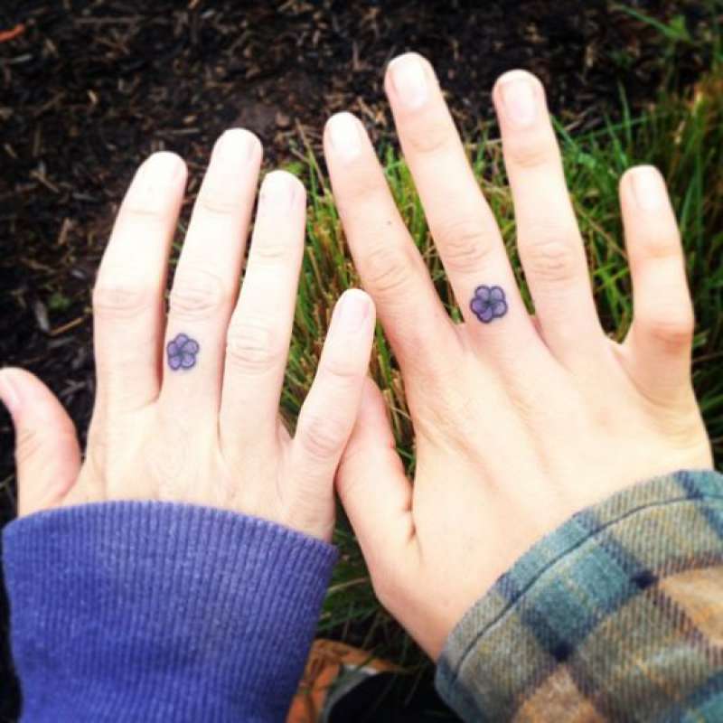 Mãos femininas tatuadas com flor