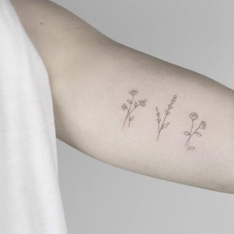 Flores e plantas tatuadas no braço