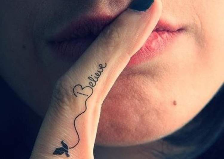 Frase tatuada no dedo da mão
