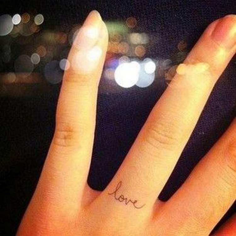 Tatuagem com a palavra love no dedo da mão