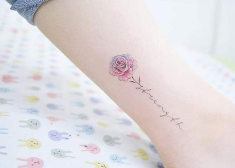 Tatuagem delicada om o desenho de flor
