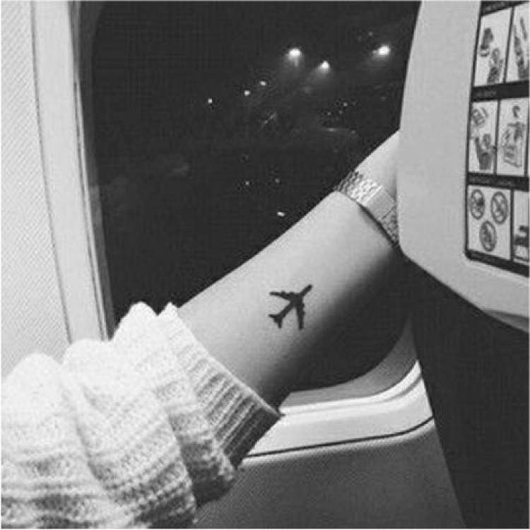 Tatuagem delicada de avião no braço