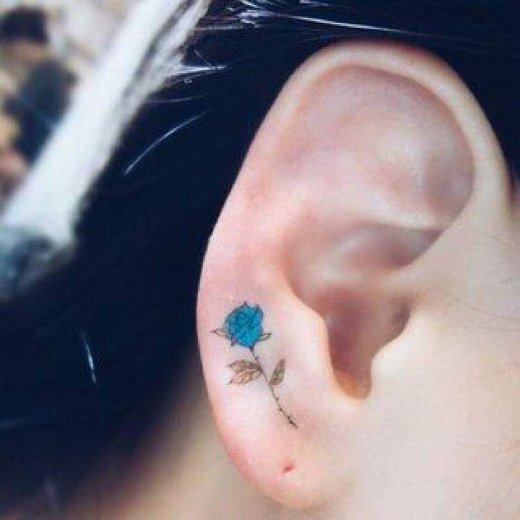 Tatuagem delicada de flor na orelha