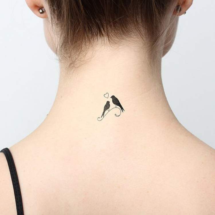 Tatuagem delicada no lado de trás do pescoço com dois pássaros namorando