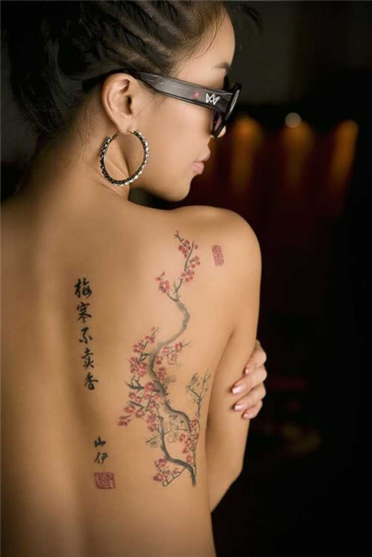 Mulher com parte das costas tatuada