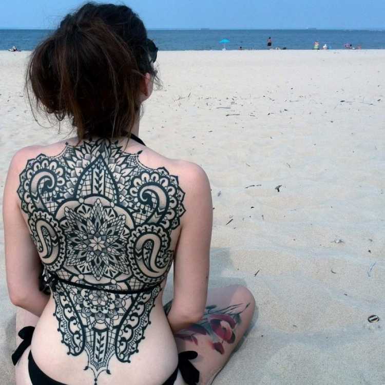 Mulher com tatuagem nas costas