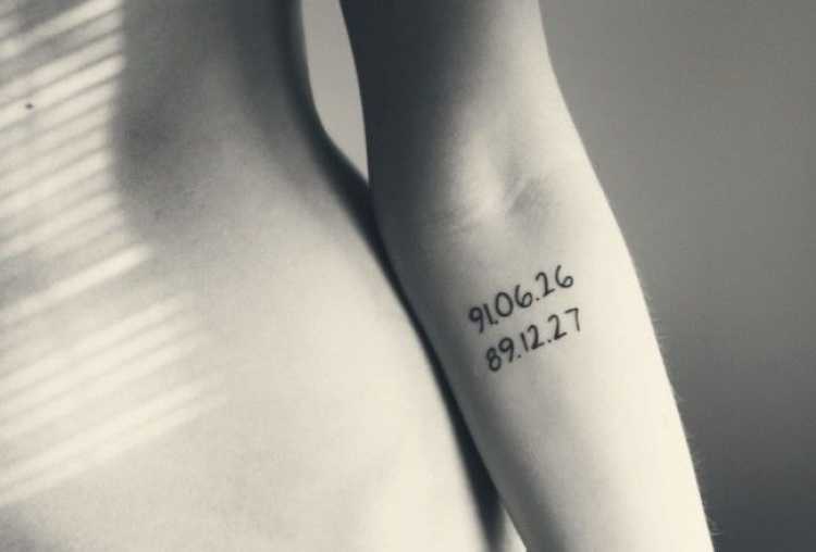 Números tatuados no braço de uma mulher