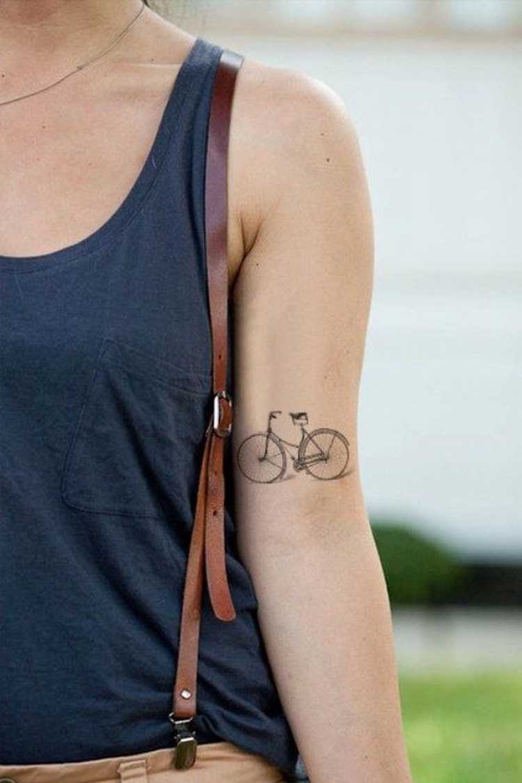 Tatuagem com o desenho de uma bicicleta no braço