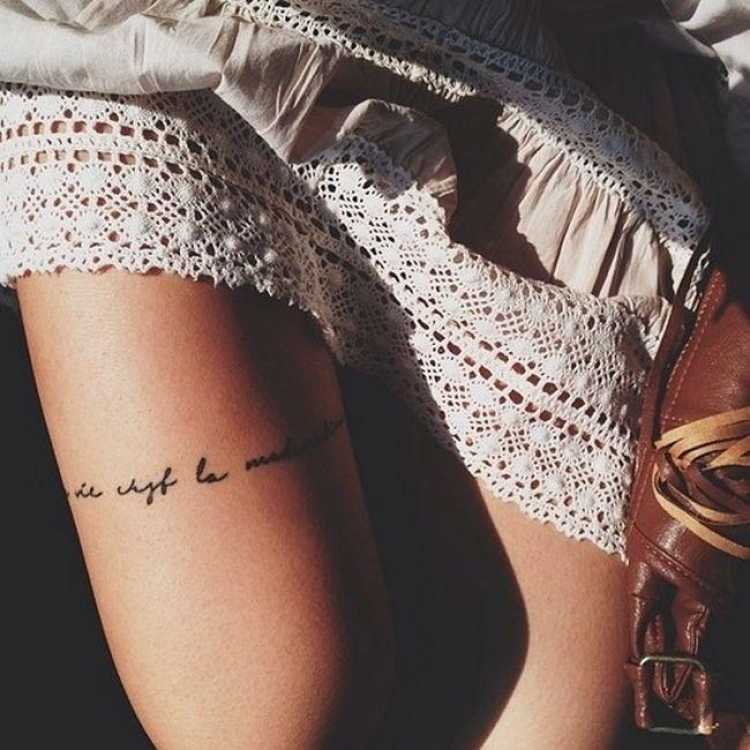 tatuagem feminina delicada com dizeres na coxa