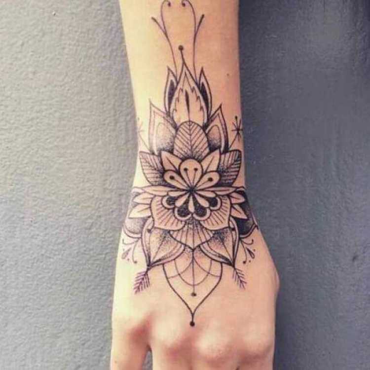Tatuagem feminina na mão e no braço